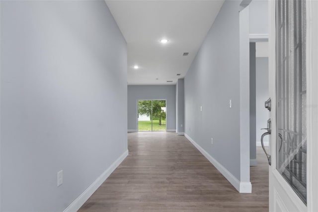 hallway featuring recessed lighting, wood finished floors, visible vents, and baseboards