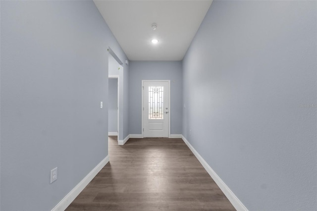 doorway featuring dark wood finished floors and baseboards