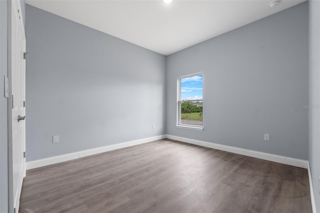 empty room with baseboards and wood finished floors