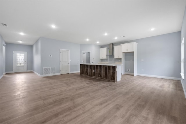 unfurnished living room featuring sink and light hardwood / wood-style flooring