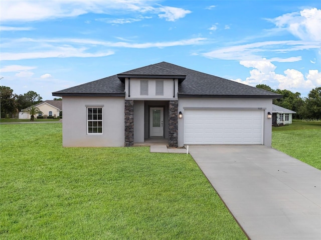 prairie-style home featuring a garage, a shingled roof, a front lawn, and concrete driveway