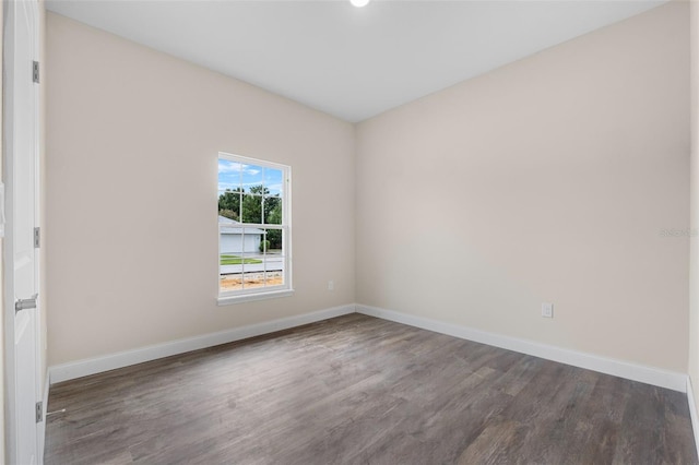 empty room featuring baseboards and wood finished floors