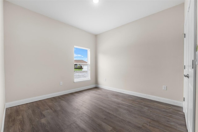 empty room with dark hardwood / wood-style flooring