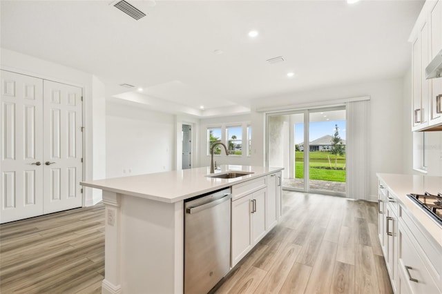 kitchen featuring light countertops, visible vents, a sink, and stainless steel dishwasher