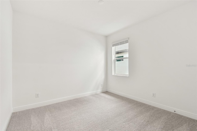 carpeted empty room with baseboards