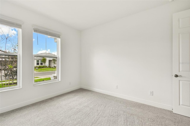 empty room with carpet and baseboards