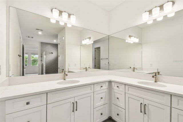 full bathroom with a stall shower, a sink, and double vanity