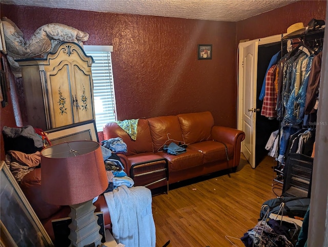 living room with a textured ceiling and hardwood / wood-style flooring