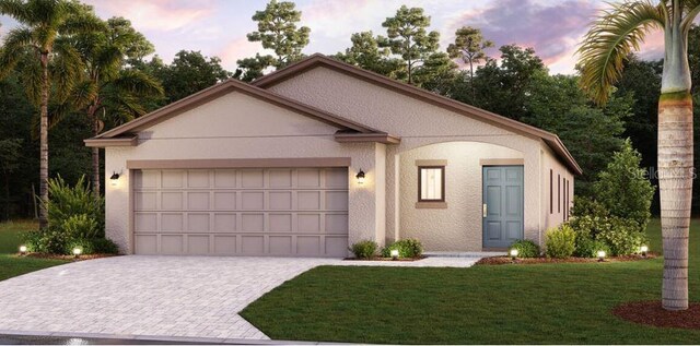 view of front of property featuring a garage and a lawn