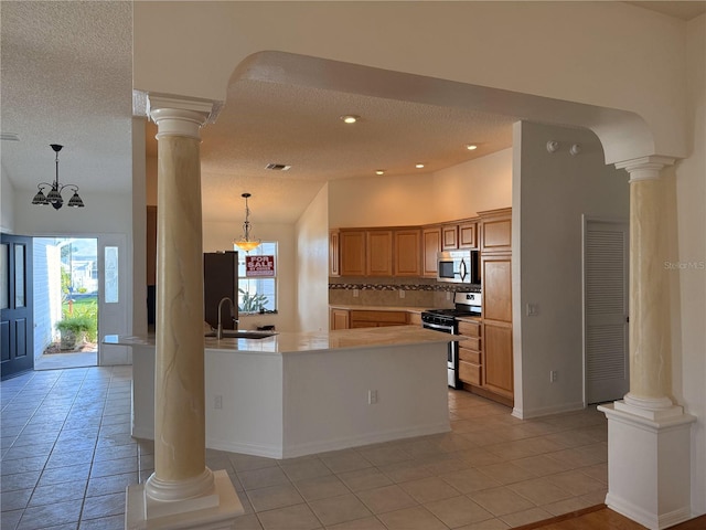 kitchen with appliances with stainless steel finishes, a textured ceiling, an inviting chandelier, and backsplash