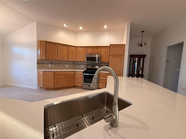 kitchen with hanging light fixtures, stainless steel appliances, an inviting chandelier, a textured ceiling, and decorative backsplash