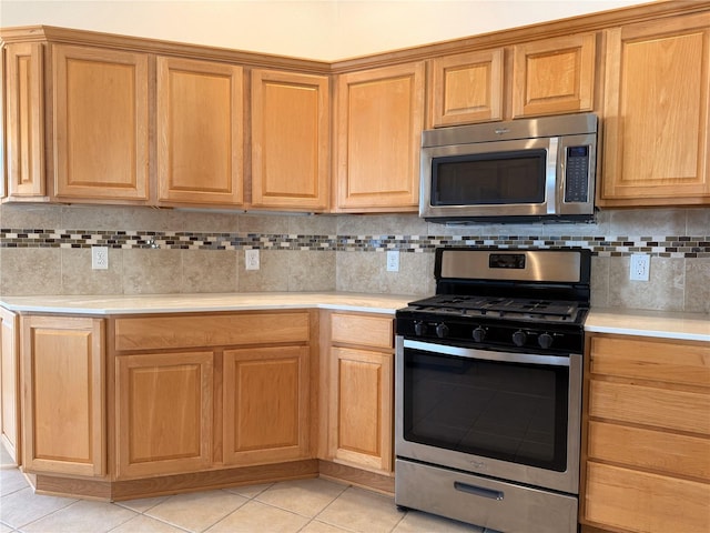 kitchen featuring light tile patterned floors, appliances with stainless steel finishes, and tasteful backsplash