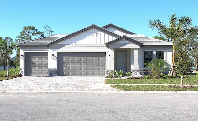 view of front of house with a garage, decorative driveway, and a tiled roof