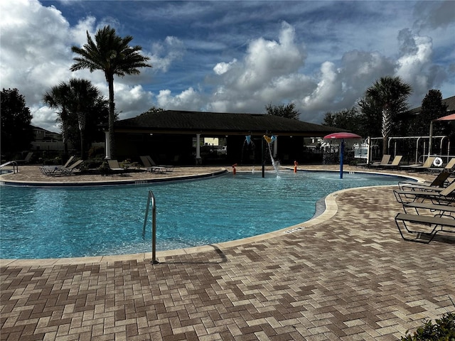 view of swimming pool featuring pool water feature and a patio