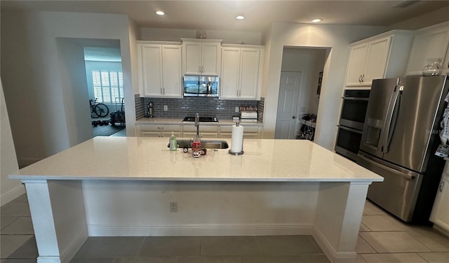 kitchen with white cabinetry, a center island with sink, stainless steel appliances, and sink