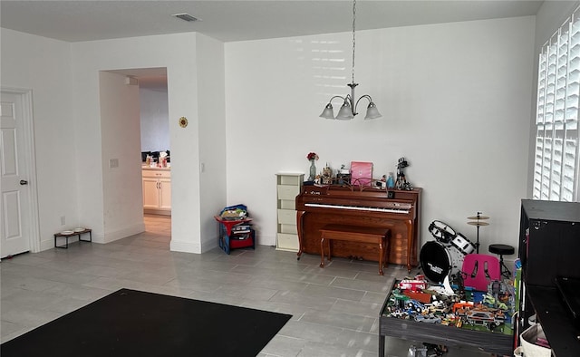 misc room with light tile patterned floors and an inviting chandelier