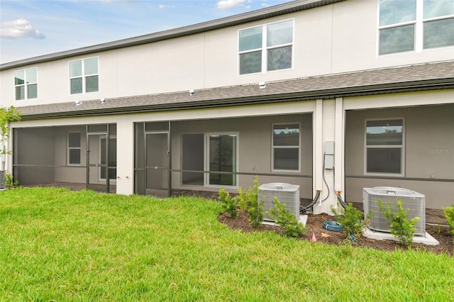 rear view of house with a lawn and central air condition unit