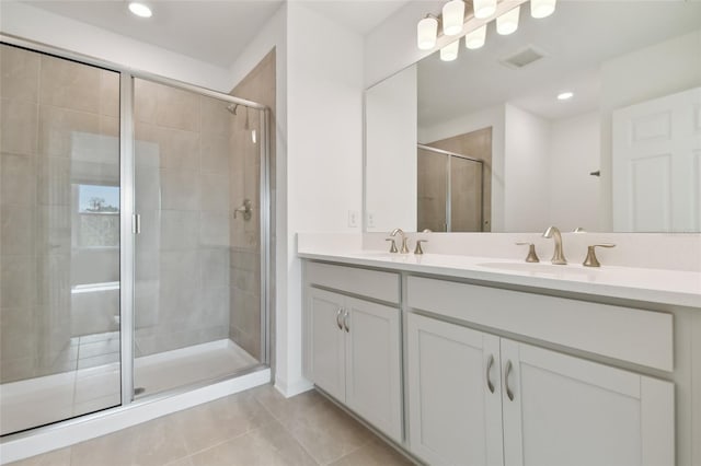 bathroom featuring tile patterned flooring, vanity, and a shower with shower door