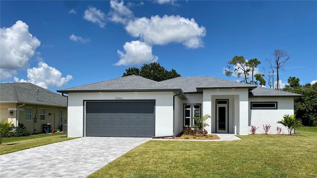 view of front facade with decorative driveway, a front yard, stucco siding, and an attached garage