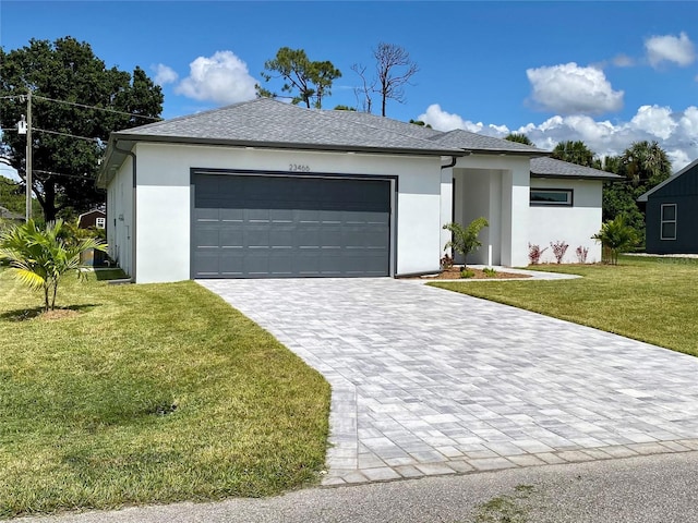ranch-style house with a garage, decorative driveway, stucco siding, and a front lawn
