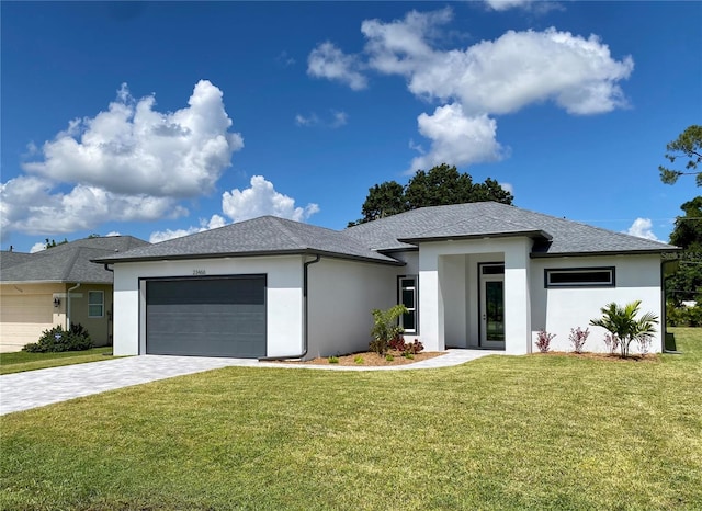 prairie-style home featuring a garage and a front lawn