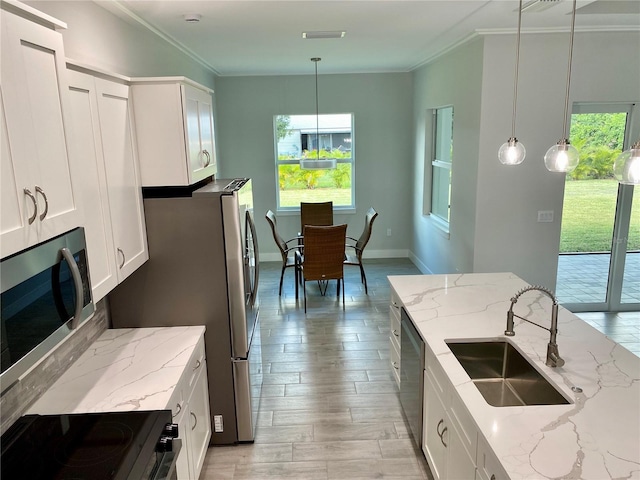 kitchen with white cabinetry, a sink, stainless steel appliances, and crown molding
