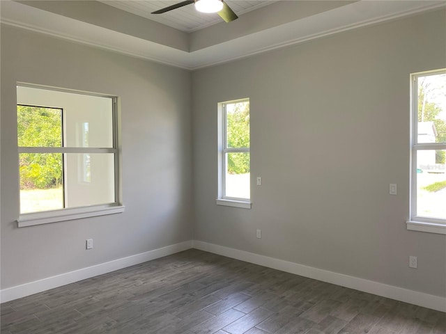 empty room featuring a ceiling fan, dark wood-style flooring, plenty of natural light, and baseboards