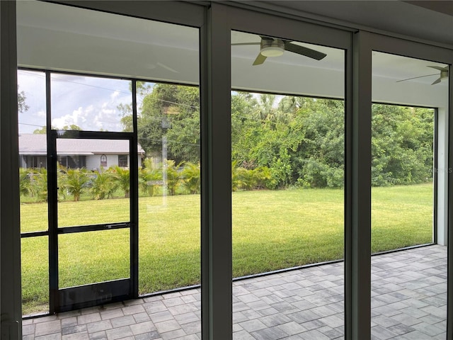 unfurnished sunroom with ceiling fan