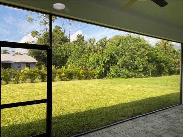 unfurnished sunroom featuring ceiling fan