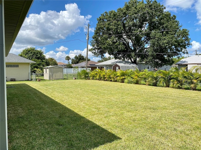 view of yard with a storage unit, fence, and an outdoor structure