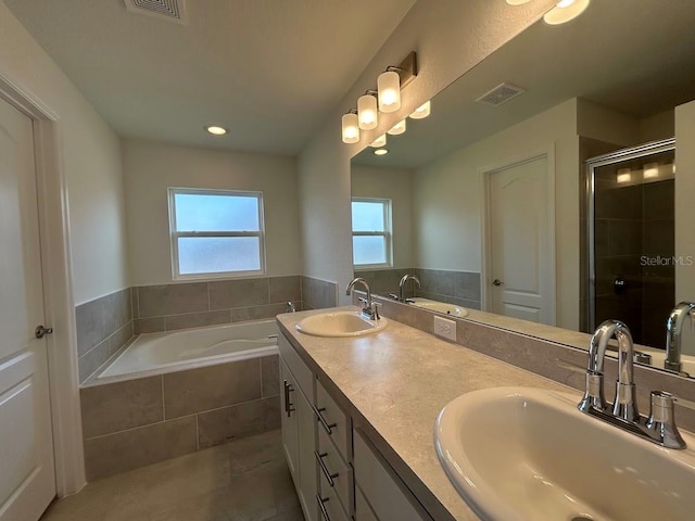 bathroom with a stall shower, a sink, and visible vents