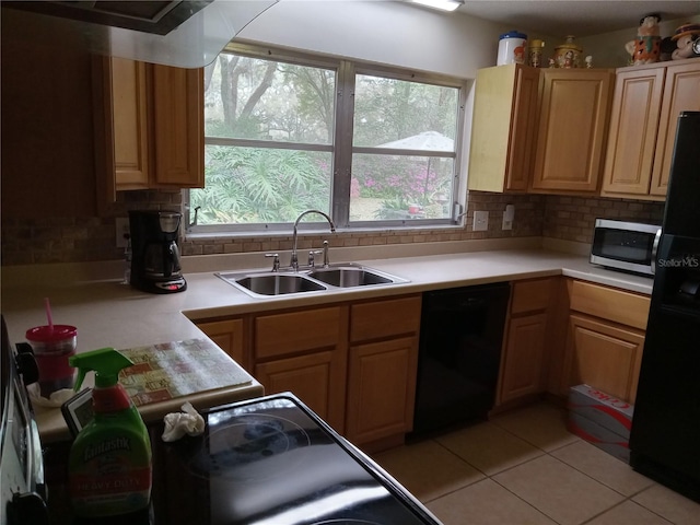 kitchen with tasteful backsplash, sink, light tile patterned floors, and black appliances