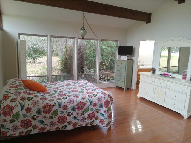 bedroom with hardwood / wood-style flooring and vaulted ceiling with beams