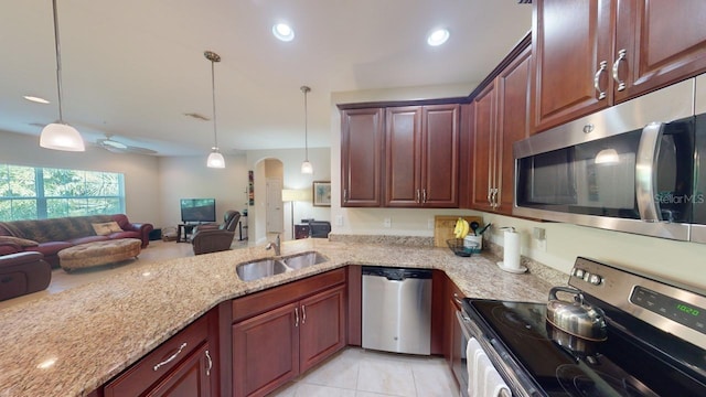 kitchen with light tile patterned floors, pendant lighting, stainless steel appliances, and sink