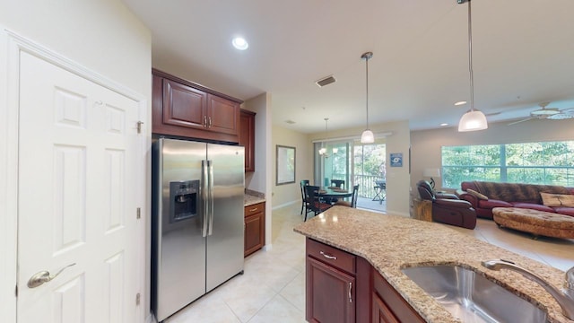 kitchen featuring stainless steel fridge with ice dispenser, sink, decorative light fixtures, light stone countertops, and ceiling fan