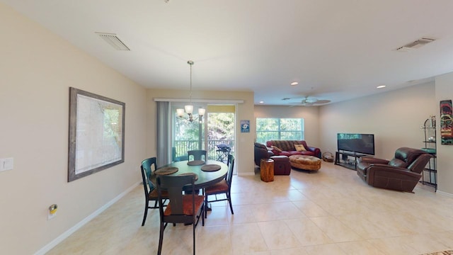 tiled dining room with ceiling fan with notable chandelier