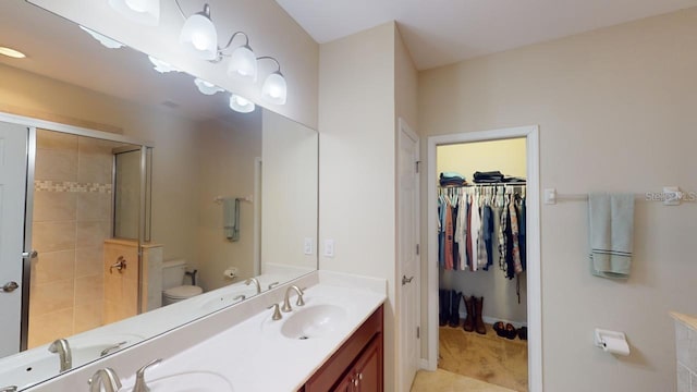 bathroom with vanity, toilet, a shower with door, and tile patterned floors