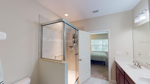 bathroom featuring tile patterned flooring, walk in shower, vanity, and toilet