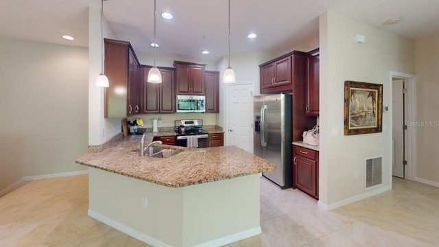 kitchen featuring light stone counters, pendant lighting, sink, kitchen peninsula, and appliances with stainless steel finishes