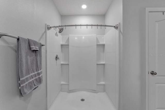 bathroom featuring walk in shower and a textured ceiling