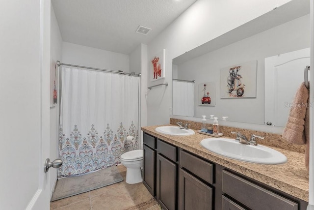 bathroom featuring a textured ceiling, tile patterned flooring, vanity, and toilet