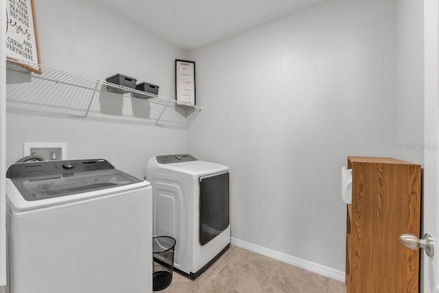 laundry room with washer and clothes dryer and light tile patterned flooring