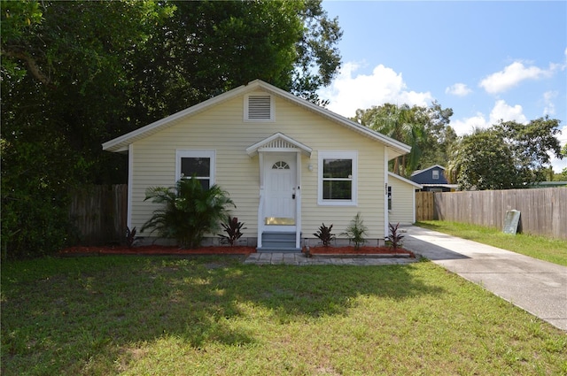 bungalow-style house featuring a front lawn