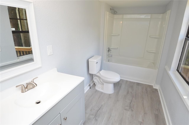 full bathroom with shower / bathing tub combination, hardwood / wood-style flooring, vanity, and toilet