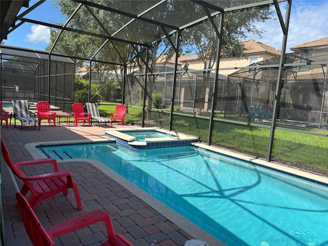 view of swimming pool with a patio, a pool with connected hot tub, and glass enclosure