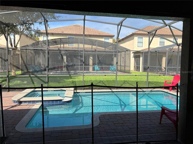 view of swimming pool featuring glass enclosure, an in ground hot tub, a lawn, and a patio area