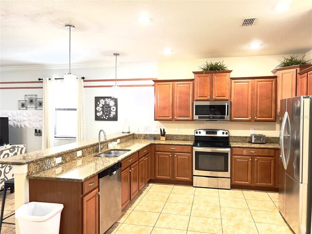 kitchen featuring sink, a kitchen bar, appliances with stainless steel finishes, decorative light fixtures, and crown molding