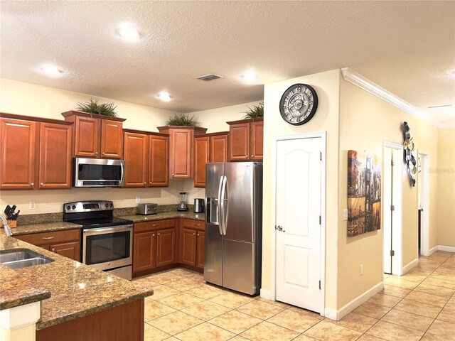 kitchen featuring light tile patterned floors, stainless steel appliances, a textured ceiling, crown molding, and sink