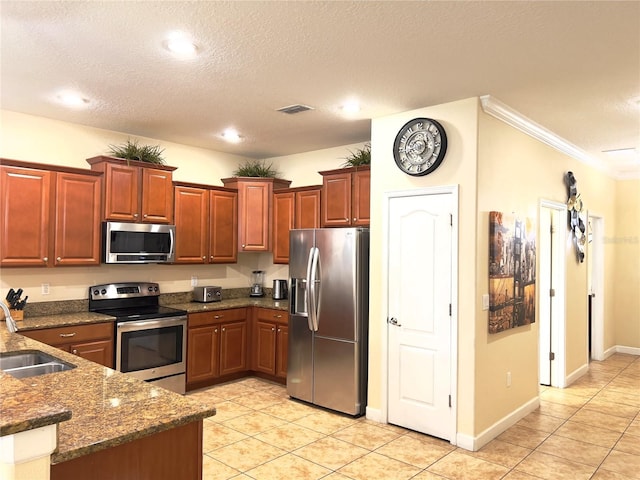 kitchen featuring dark stone countertops, light tile patterned floors, visible vents, appliances with stainless steel finishes, and a sink