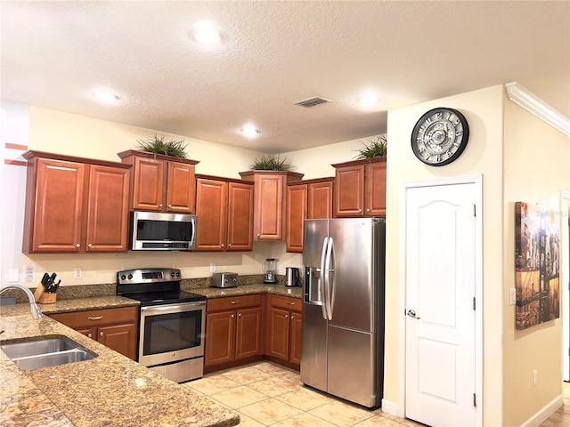 kitchen featuring visible vents, light tile patterned floors, a sink, appliances with stainless steel finishes, and a textured ceiling
